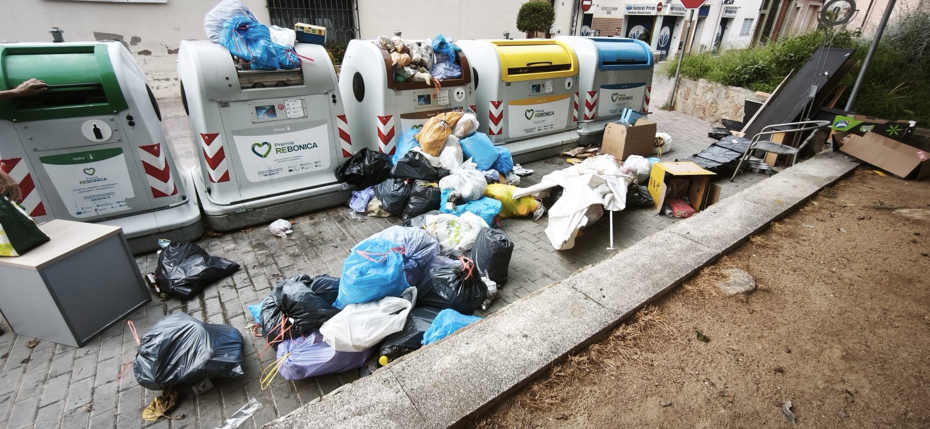 Bosses i residus voluminosos acumulats davant d’una illa de contenidors